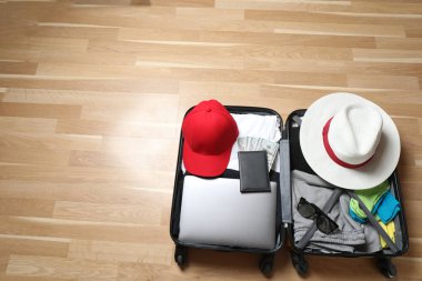 Bavul, şapka ve güneş gözlüğü, ahşap bavulun yanında.