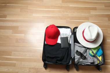 Bavul, şapka ve güneş gözlüğü, ahşap bavulun yanında.