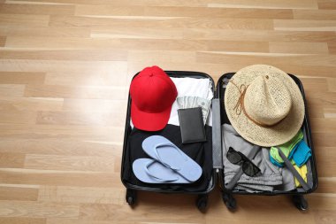 Bavul, şapka ve güneş gözlüğü, ahşap bavulun yanında.