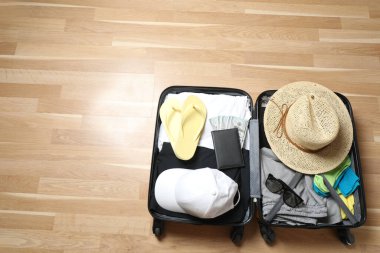 Bavul, şapka ve güneş gözlüğü, ahşap bavulun yanında.