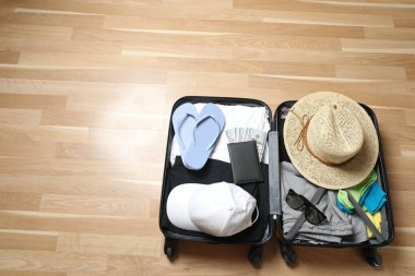 Bavul, şapka ve güneş gözlüğü, ahşap bavulun yanında.