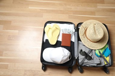 Bavul, şapka ve güneş gözlüğü, ahşap bavulun yanında.