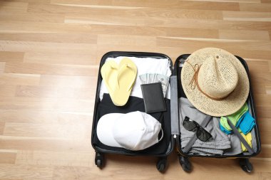 Bavul, şapka ve güneş gözlüğü, ahşap bavulun yanında.