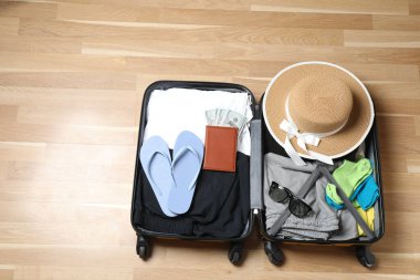 Bavul, şapka ve güneş gözlüğü, ahşap bavulun yanında.