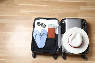 Bavul, şapka ve güneş gözlüğü, ahşap bavulun yanında.