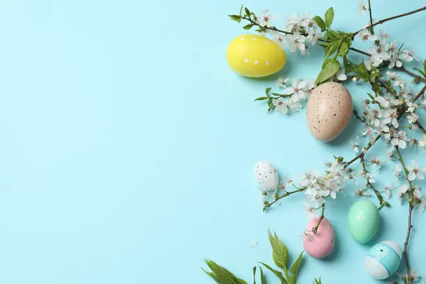 Mavi arka planda yumurta ve çiçekli paskalya kompozisyonu