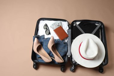 Yerde farklı giysiler olan kadın bavulu.