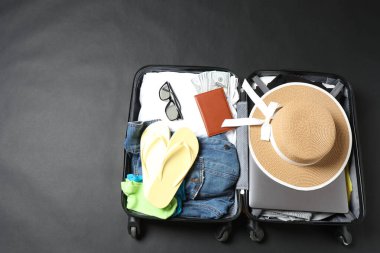 gri arka planda şapka, güneş gözlüğü ve pasaportlu seyahat aksesuarları