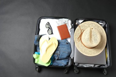 Aksesuarlı bavul, gri arka planda şapka. Düz yat. seyahat kavramı