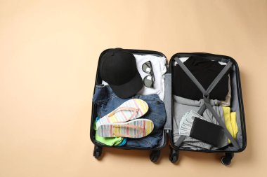 Bavullu seyahat çantası ve beyaz arka planda şapka.