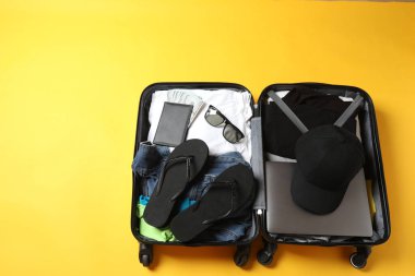 bavul, seyahat aksesuarları ve tahta arka planda maske