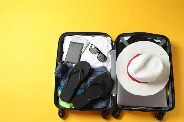 Elbiseli bavul ve arka planda şapka