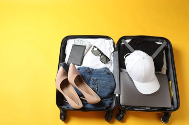 Bavulu ve aksesuarları olan kadın renk arka planında seyahat ediyor.