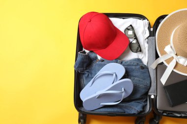 Şapkalı bavul, güneş gözlüğü ve beyaz arka planda şapka.