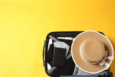 Hafif arka planda şapka ve güneş gözlüklü bavul