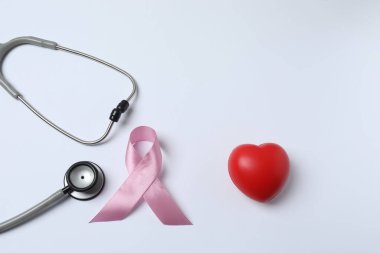 Beyaz arka planda kalp ve steteskop izole edilmiş pembe göğüs kanseri farkındalığı ayı