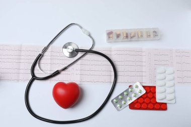 Steteskopta tıbbi ilaçlar, beyaz arka planda kalp şekli.