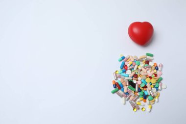 Beyaz arka planda farklı haplardan yapılmış kalp.