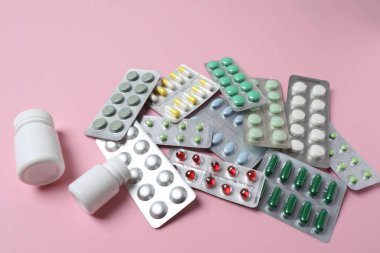 Aydınlatma arka planında su toplayan farklı tipte haplar.