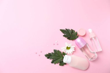 Güzellik kozmetik ürünleri ve pembe arka planda çiçek