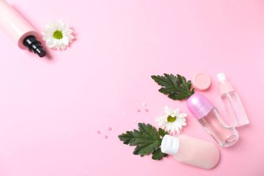 Pembe arka planda çiçekli kozmetikler