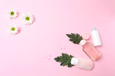Pembe arka planda kozmetik şişeleri olan düz konum, metin için boşluk