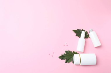 Boş kozmetik şişesinin üst görüntüsü ve pembe arka planda boş bir kağıt. düz alan, kopyala boşluk.