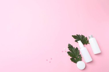 Pembe arka planda yeşil yapraklı doğal organik kozmetik ürünlerinin üst görüntüsü, panoramik çekim