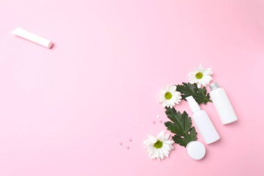Pembe arka planda kozmetik ürünleri olan düz konum