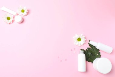 Kozmetik ürünleri düzlüğü ve beyaz arkaplan çiçekleri