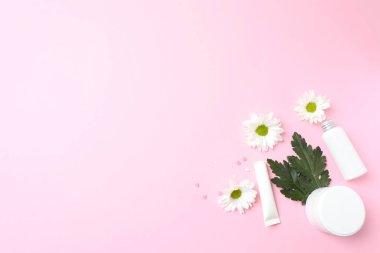 Beyaz çiçekler ve renkli bir arka planda kozmetik krem. düz yatış, üst görünüm.