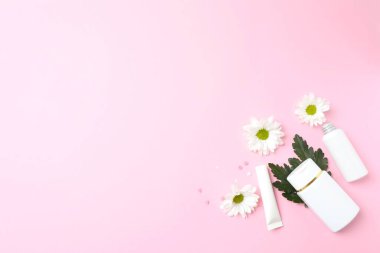 Pembe arka planda beyaz kozmetik ürünler, üst manzara. düz yat