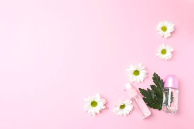 Pembe arka planda kozmetik şişesiyle düz konum.