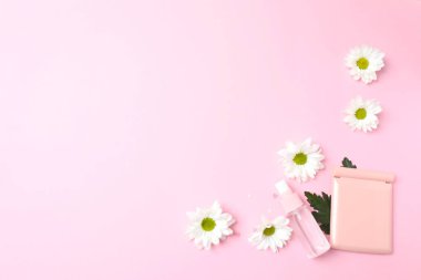 Çiçekli ve pembe arka planda hediye kutusu olan boş beyaz kağıt kartın düz uzantısı. Kopyalama alanı olan üst görünüm. Minimum yaz tatili, sevgililer günü.