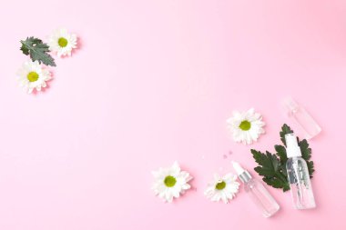 Pembe arka planda farklı çiçek ve hapların bileşimi. düz yatış, üst görünüm.