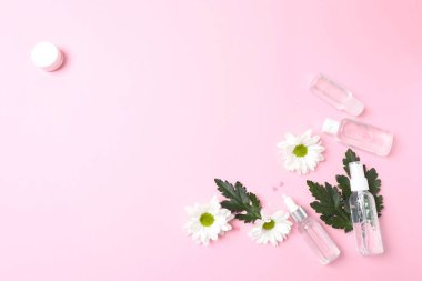 Çiçeklerin üst görüntüsü ve pembe arka planda haplar, düz yatış. tıp konsepti.