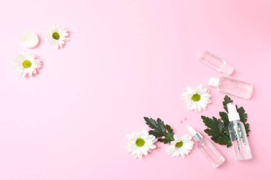 Beyaz arka planda çiçekler, kozmetik ürünler ve aksesuarlarla bezenmiş. güzellik, spa, moda, blog, düz yatak, üst görünüm.