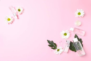 hafif arkaplanda kozmetik ürünleri ve çiçeklerle düz konum
