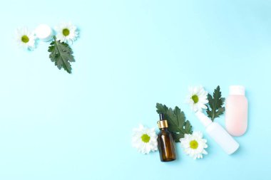 Renkli arkaplanda kozmetik şişeler ve çiçekler