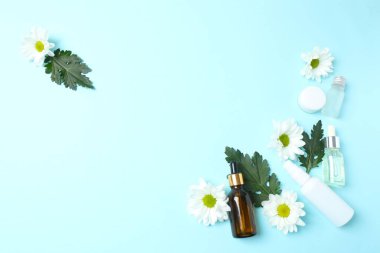 Renkli arka planda gerekli yağ şişesi ve çiçeklerle kompozisyon