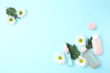 Gerekli yağ şişesi, taze çiçekler ve hafif arka planda haplar. Metin için boşluk olan üst görünüm