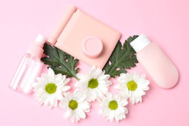 düz konum kozmetik aksesuarları ve pembe arka planda çiçek