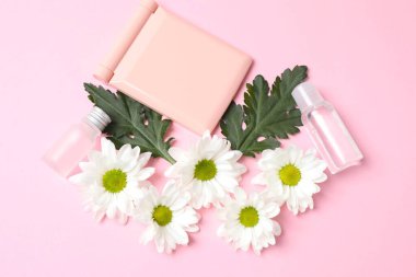 pembe arka planda çiçek ve kozmetik yatağı, üst görünüm
