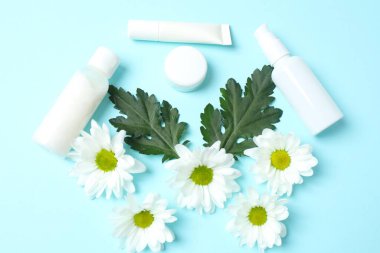 Renkli arka planda kozmetik ürünleri ve çiçekler