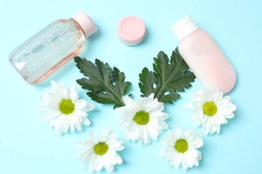 hafif arka planda kozmetik ürünleri ve çiçeklerle düz konum, yakın plan