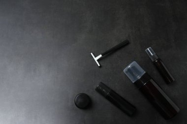 Siyah arka planda siyah bir parfüm ve kozmetik şişesi.