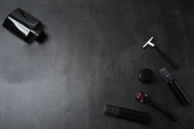 Siyah desenli arka planda kopyalama alanı olan farklı makyaj ürünleri seti