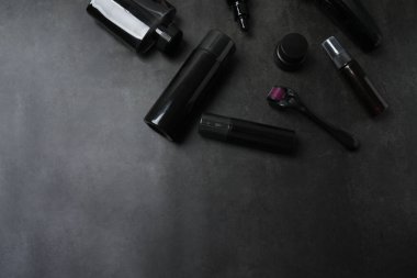 Siyah arka planda kozmetik ve dekoratif elementlerle bezenmiş düz bir yapı. Metin için boşluk