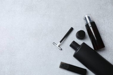 Gri arkaplanda kozmetik ürünleri bulunan düz konum