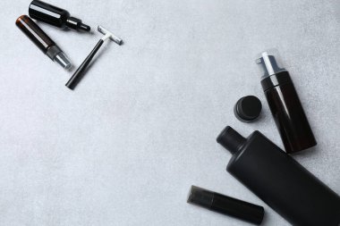 Gri arkaplanda farklı makyaj aksesuarları bulunan düz konum